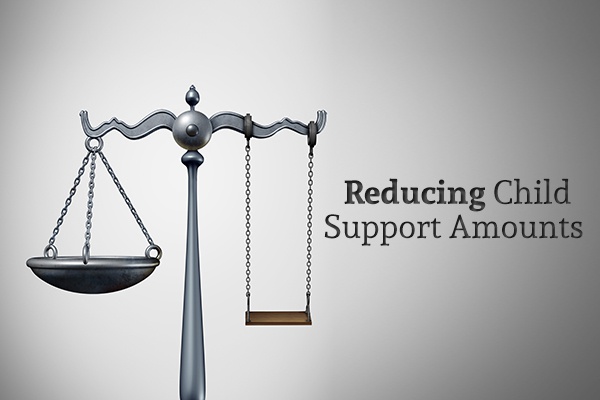 A Justice scale with one of the scales replaced with a swing beside the words "Reducing Child Support Amounts"