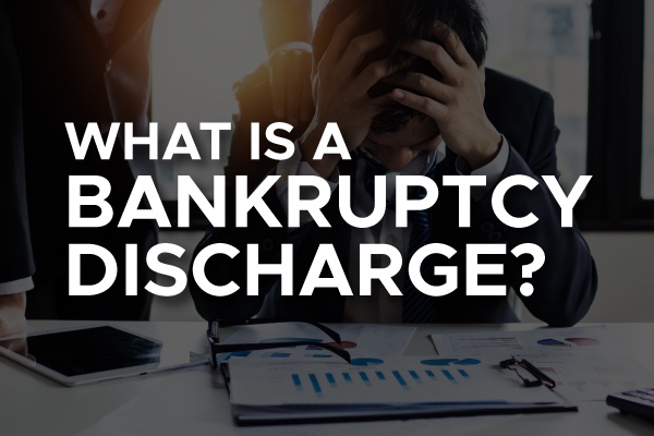 A person looking over their finances with the words, "what is a bankruptcy discharge?"
