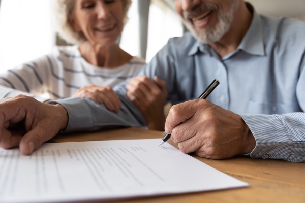 An older couple signing a will.